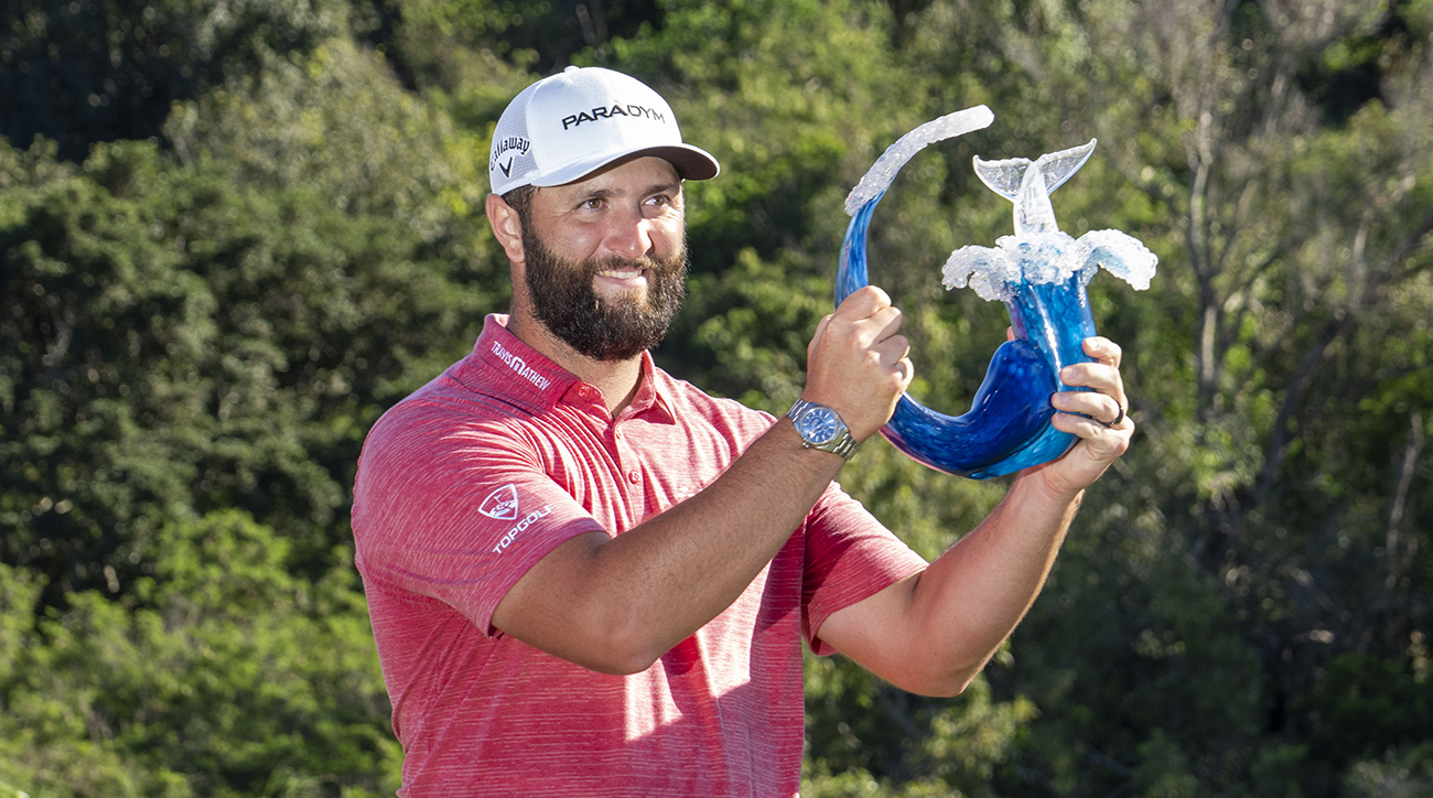 Jon Rahm hoists the trophy on the 18th hole during the final round of the Sentry Tournament of Champions golf tournament at Kapalua Resort - The Plantation Course. 